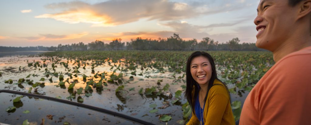 Visitors cruising through Yellow Water Billabong, surrounded by Kakadu's lush wetlands and vibrant wildlife